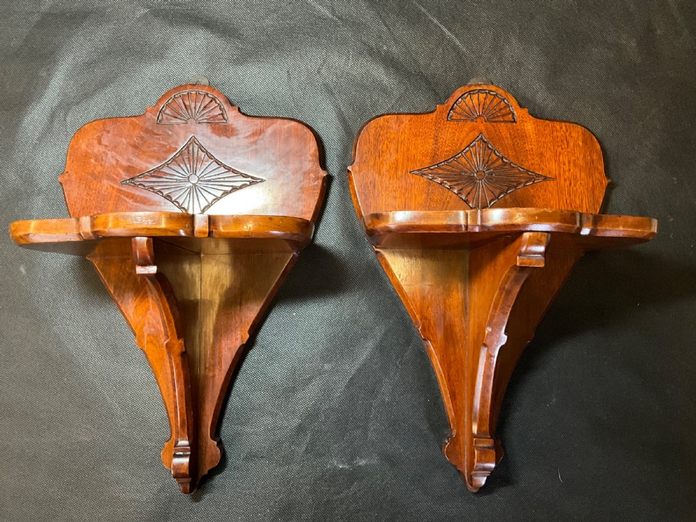 A pair of solid mahogany wall brackets