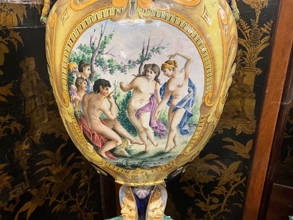 Large Italian Majolica tin-glazed earthenware vase with scrolled handles resting on an ornate matching pedestal base, decorated with painted mythological figures and relief masks. View IV