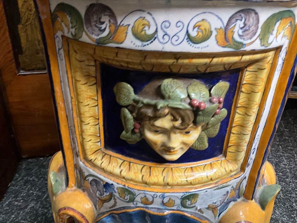 Large Italian Majolica tin-glazed earthenware vase with scrolled handles resting on an ornate matching pedestal base, decorated with painted mythological figures and relief masks. View XII