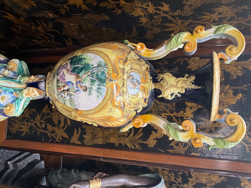 Large Italian Majolica tin-glazed earthenware vase with scrolled handles resting on an ornate matching pedestal base, decorated with painted mythological figures and relief masks. View XVI