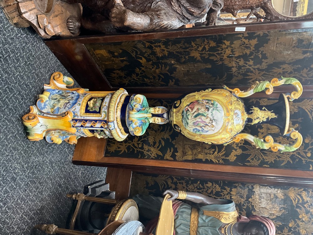 Large Italian Majolica tin-glazed earthenware vase with scrolled handles resting on an ornate matching pedestal base, decorated with painted mythological figures and relief masks. View XIX
