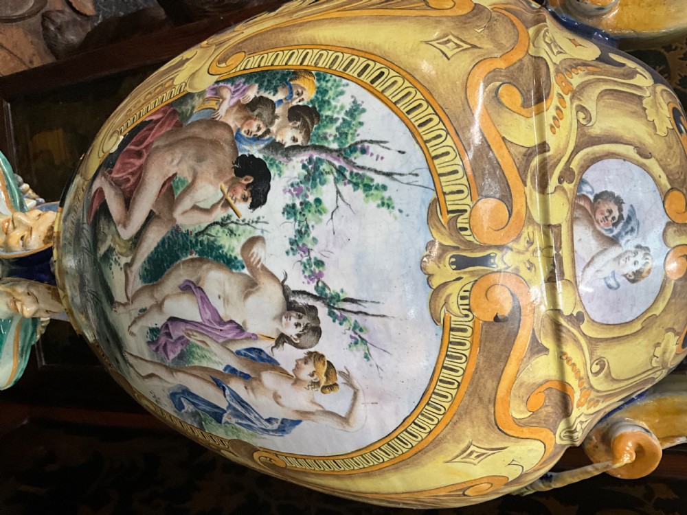 Large Italian Majolica tin-glazed earthenware vase with scrolled handles resting on an ornate matching pedestal base, decorated with painted mythological figures and relief masks. View XX