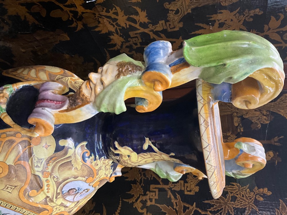 Large Italian Majolica tin-glazed earthenware vase with scrolled handles resting on an ornate matching pedestal base, decorated with painted mythological figures and relief masks. View XXII