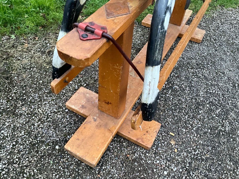 An antique carved wooden dapple grey rocking horse with real horsehair and leather tack mounted on a pine safety glider stand. View V