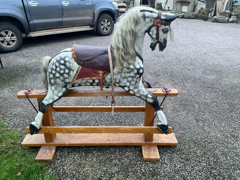 An antique carved wooden dapple grey rocking horse with real horsehair and leather tack mounted on a pine safety glider stand. View VI
