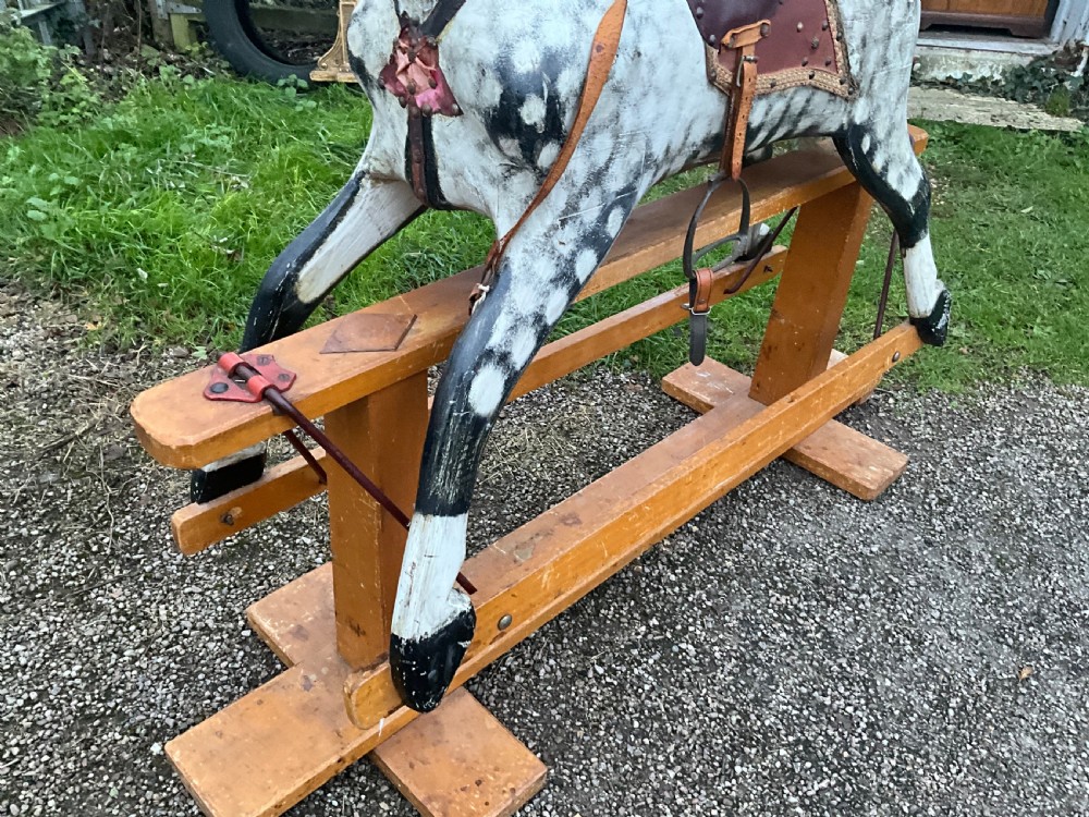 An antique carved wooden dapple grey rocking horse with real horsehair and leather tack mounted on a pine safety glider stand. View IX