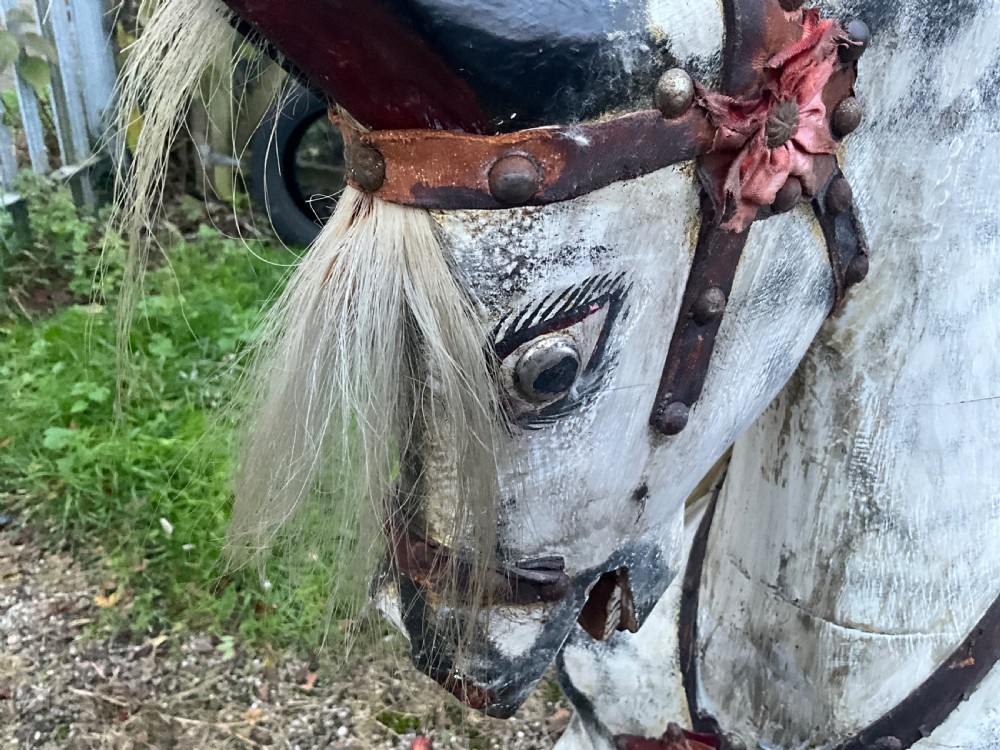 An antique carved wooden dapple grey rocking horse with real horsehair and leather tack mounted on a pine safety glider stand. View X