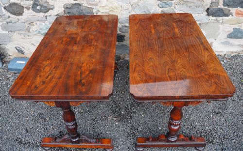 fig 1. A matched pair of antique rosewood library tables featuring polished rectangular tops, beaded aprons, turned pedestal supports, and carved trestle bases.