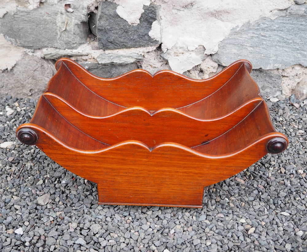 A George III mahogany double compartment cheese coaster featuring curved sides and turned end roundels.