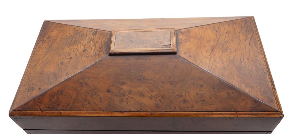 A Regency period sarcophagus-shaped tea caddy crafted from figured burr yew wood with fine string inlay. View II