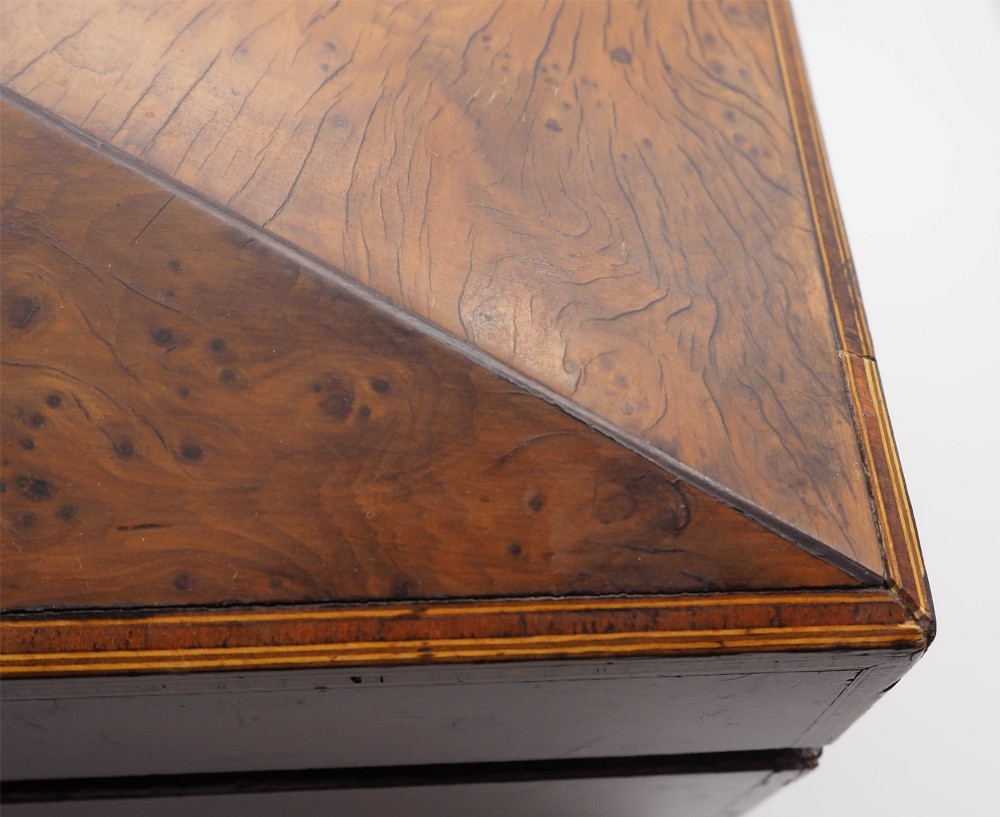 A Regency period sarcophagus-shaped tea caddy crafted from figured burr yew wood with fine string inlay. View VI