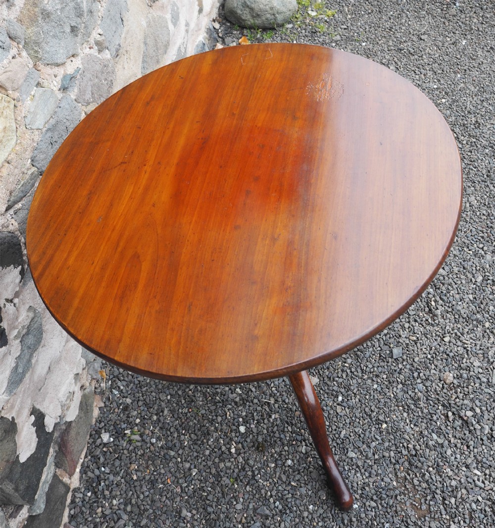 A Georgian mahogany tilt-top table shown upright with a circular top, turned central pedestal, and tripod cabriole legs. View III