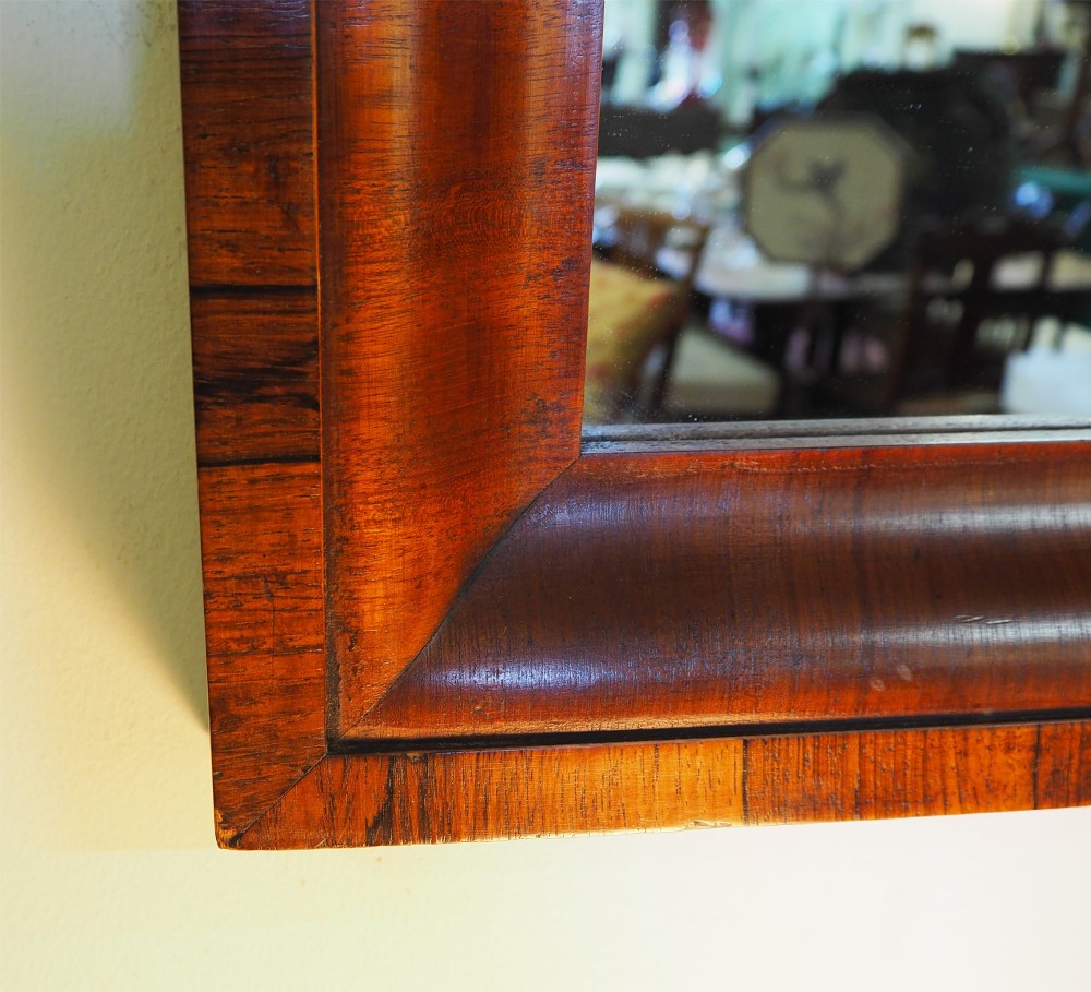 A 19th-century rectangular wall mirror featuring a deep cushion moulding frame crafted from dark rosewood veneer with mitred corners. View IV