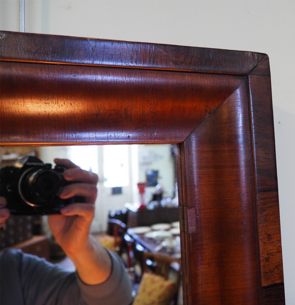 A 19th-century rectangular wall mirror featuring a deep cushion moulding frame crafted from dark rosewood veneer with mitred corners. View V