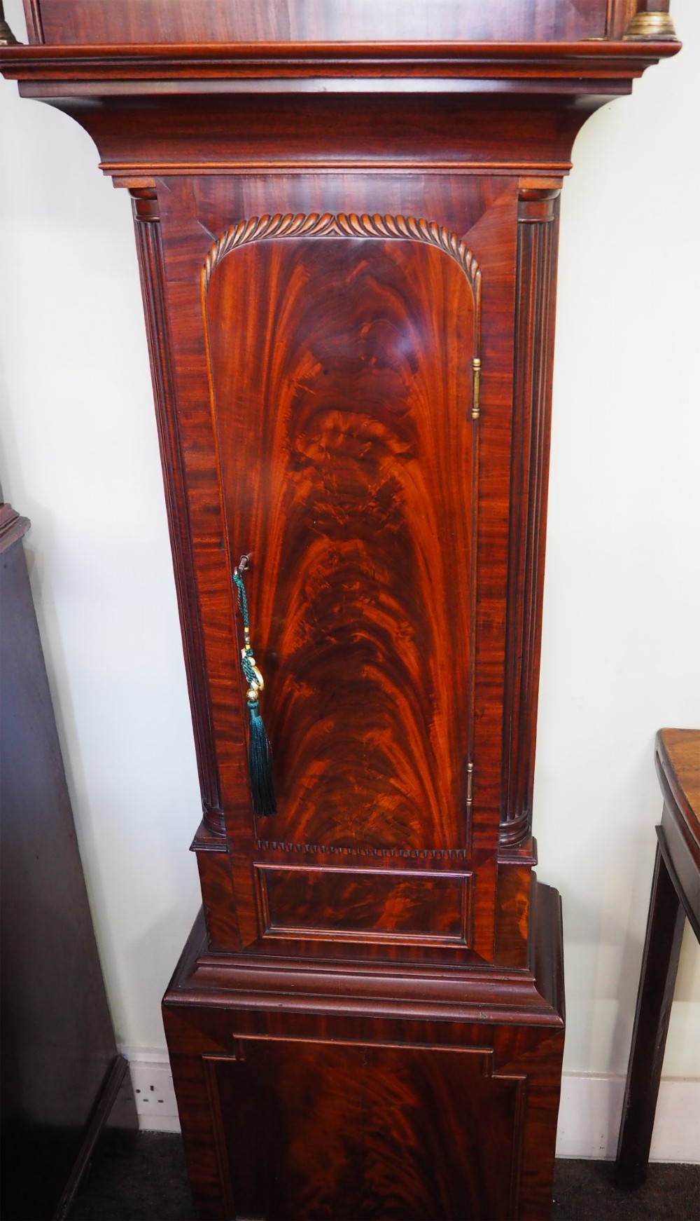 A tall Scottish mahogany longcase clock featuring a painted arch dial depicting an equestrian figure, flame mahogany cabinet trunk, and reeded side columns. View III