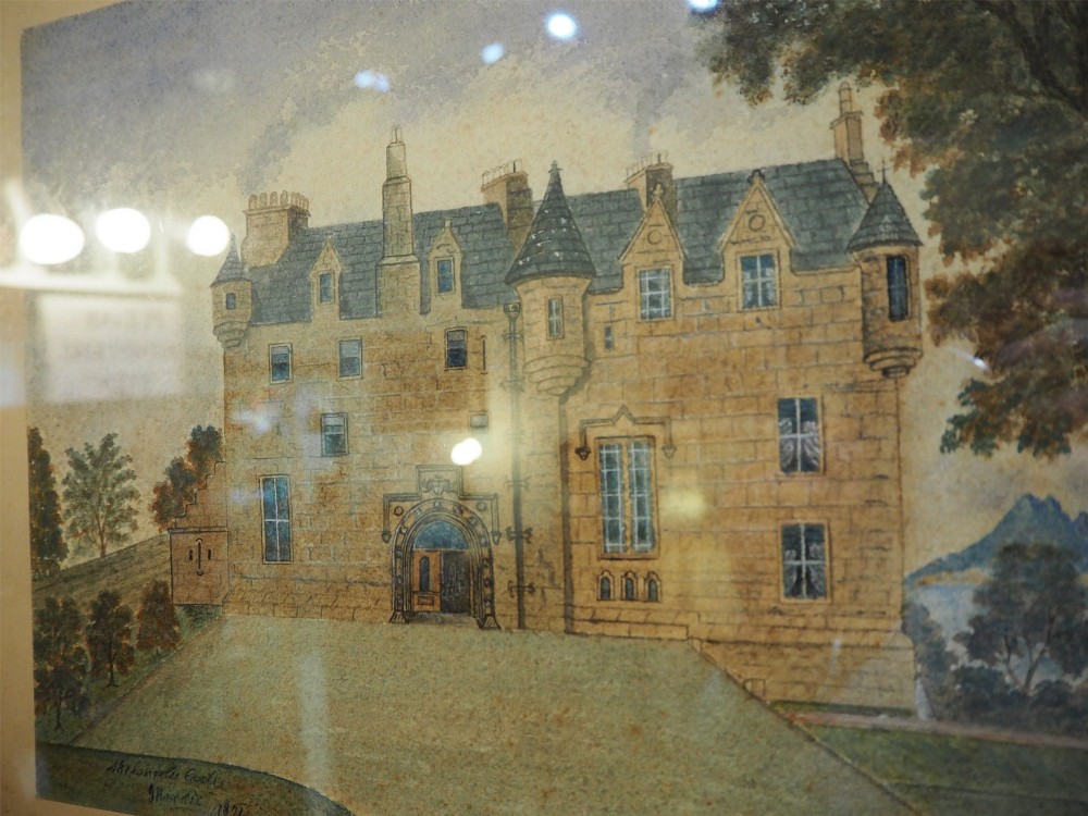 A framed 19th-century watercolour painting depicting Skelmorlie Castle against a backdrop of trees, water, and distant mountains, housed within a dark moulded frame. View II