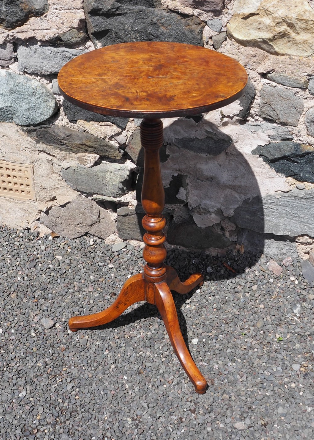 A Georgian burr elm tripod table featuring a circular top, turned pedestal column, and three splayed legs.
