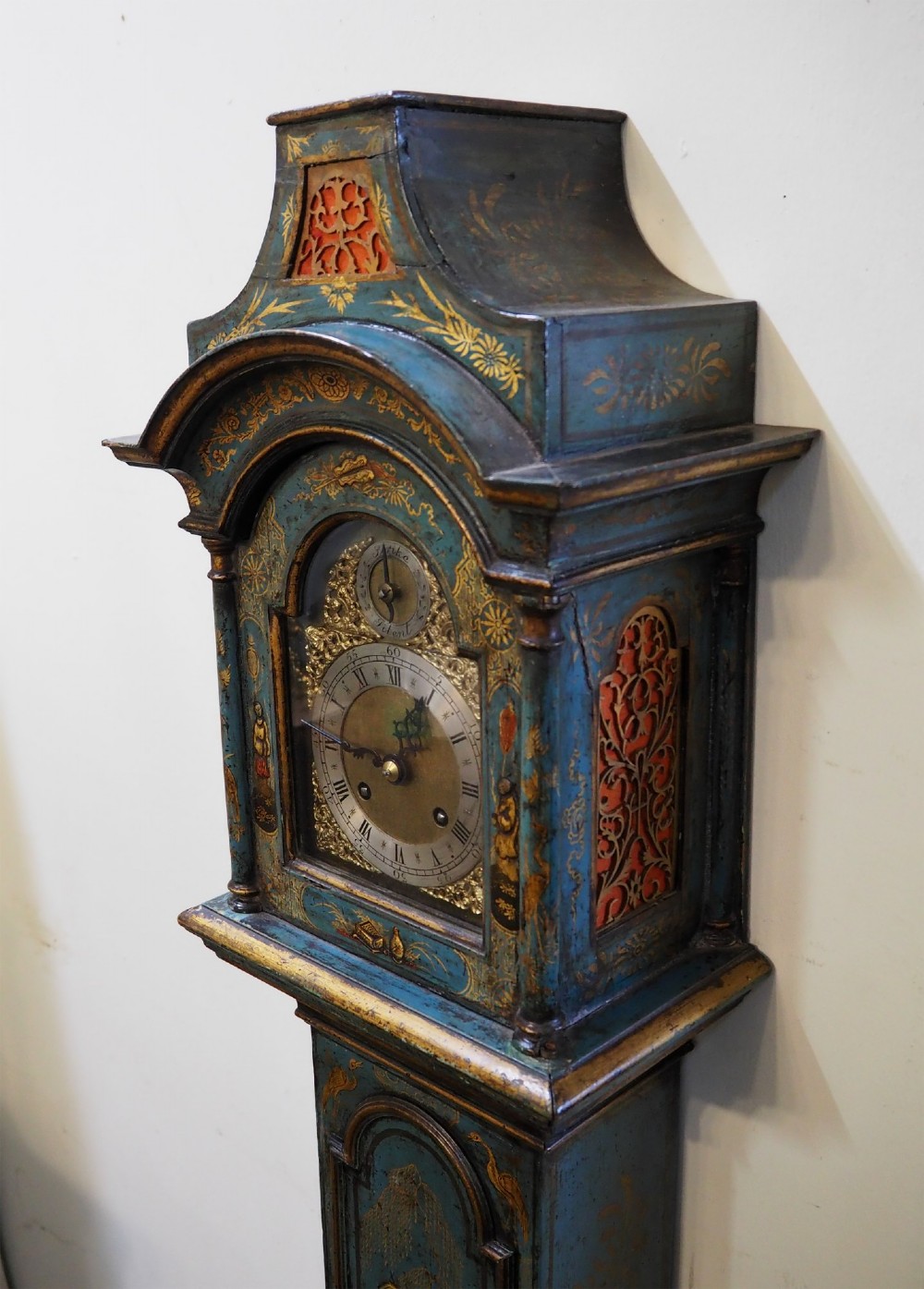A blue lacquered grandmother clock decorated with gilt chinoiserie figural scenes and an arched brass dial. View II