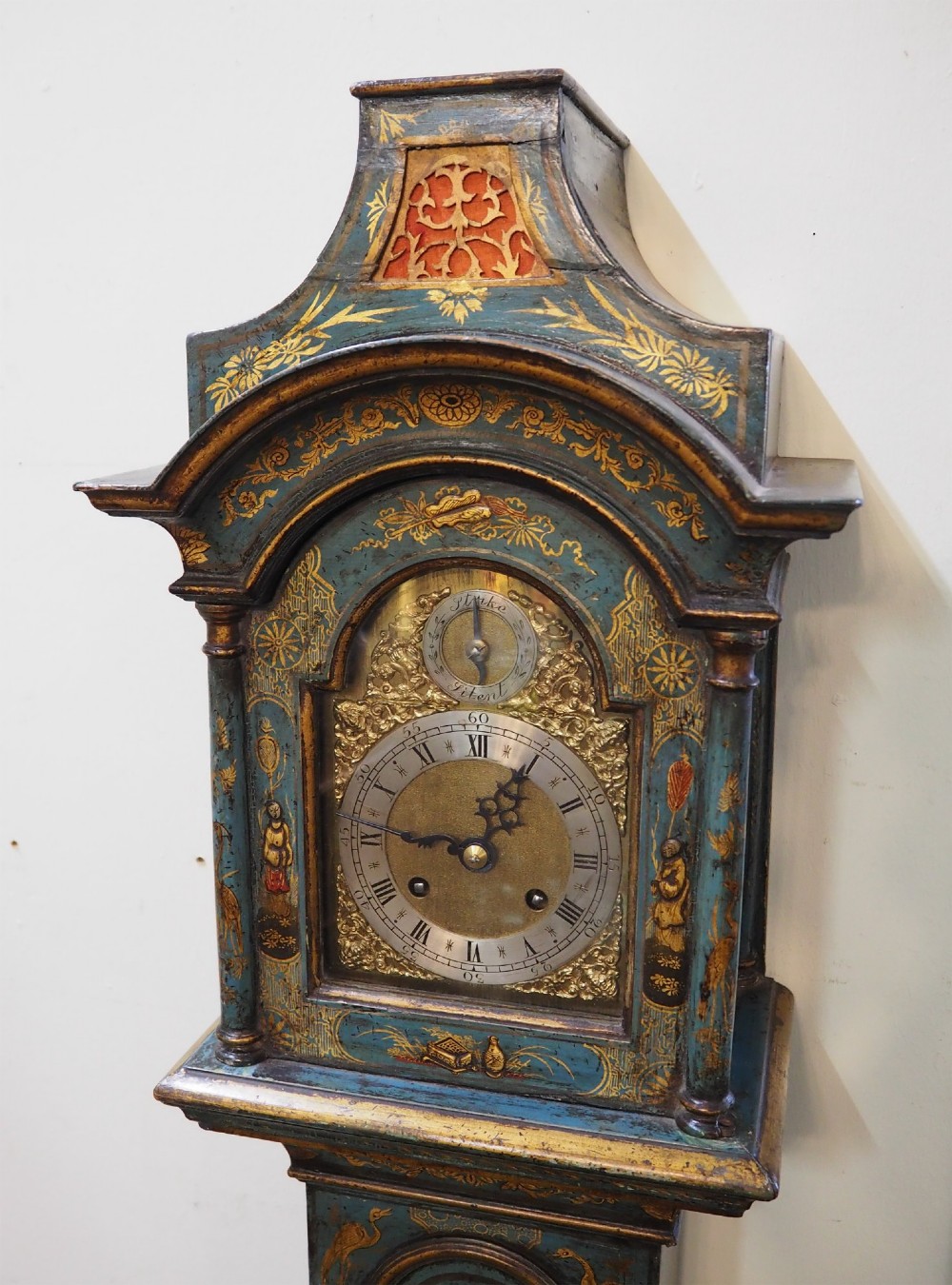 A blue lacquered grandmother clock decorated with gilt chinoiserie figural scenes and an arched brass dial. View III