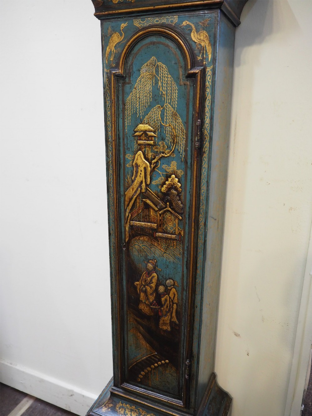 A blue lacquered grandmother clock decorated with gilt chinoiserie figural scenes and an arched brass dial. View IV