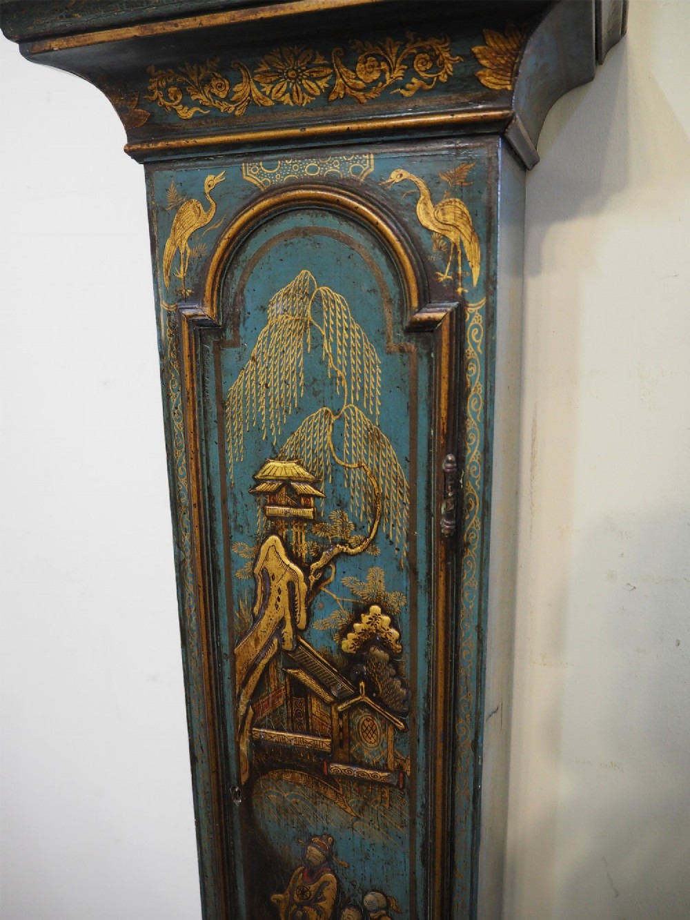 A blue lacquered grandmother clock decorated with gilt chinoiserie figural scenes and an arched brass dial. View VI
