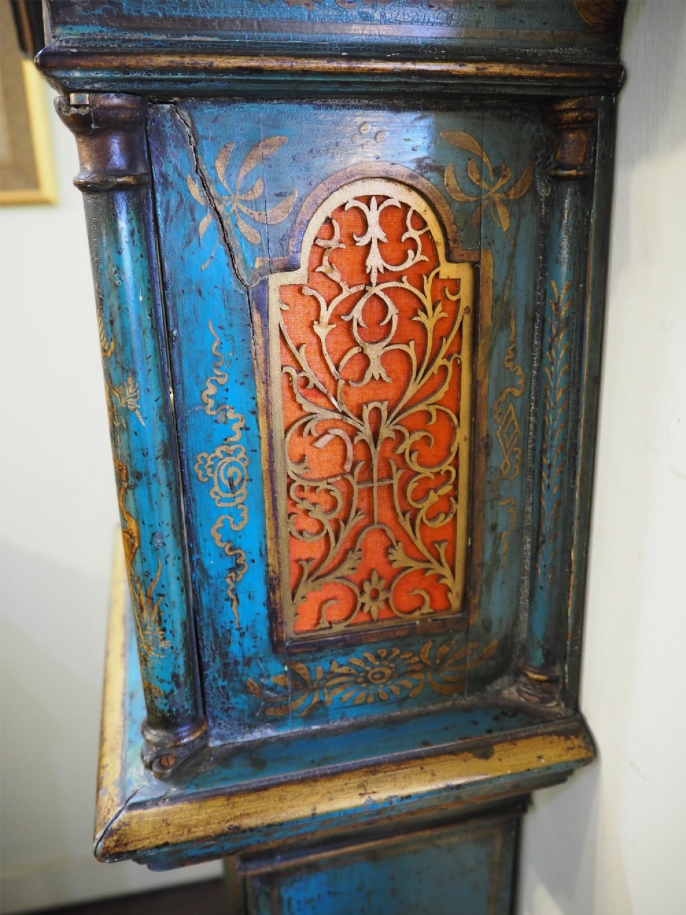A blue lacquered grandmother clock decorated with gilt chinoiserie figural scenes and an arched brass dial. View VII
