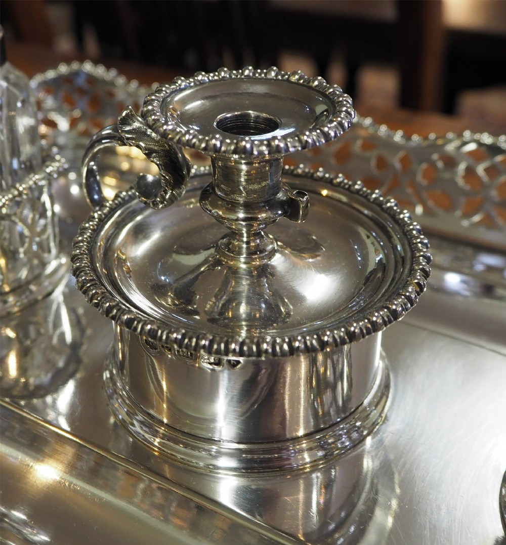 An antique silver-plated rectangular desk tray featuring a pierced gallery edge, two cut glass inkwells, a central taper holder, and a recessed pen groove. View VI