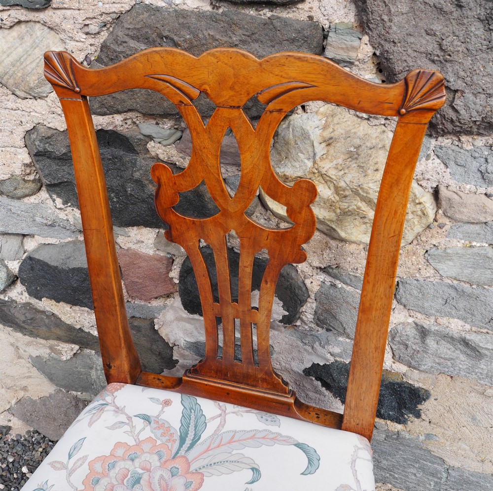An antique George II walnut side chair with a pierced splat back, floral upholstered seat, and cabriole front legs ending in carved ball and claw feet. View V