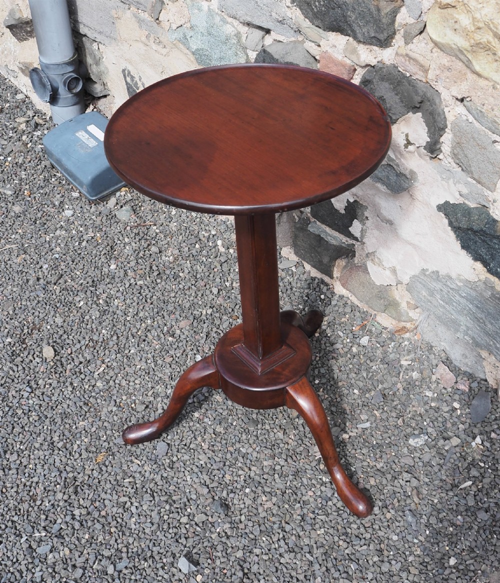 An early Georgian walnut candlestand featuring a circular dish-top surface set on a square adjustable pillar and a tripod base with cabriole legs. View II
