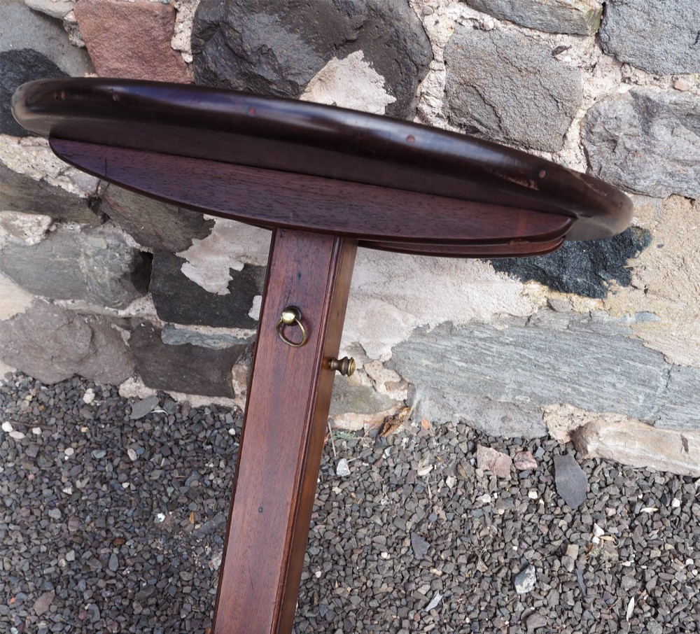 An early Georgian walnut candlestand featuring a circular dish-top surface set on a square adjustable pillar and a tripod base with cabriole legs. View VI