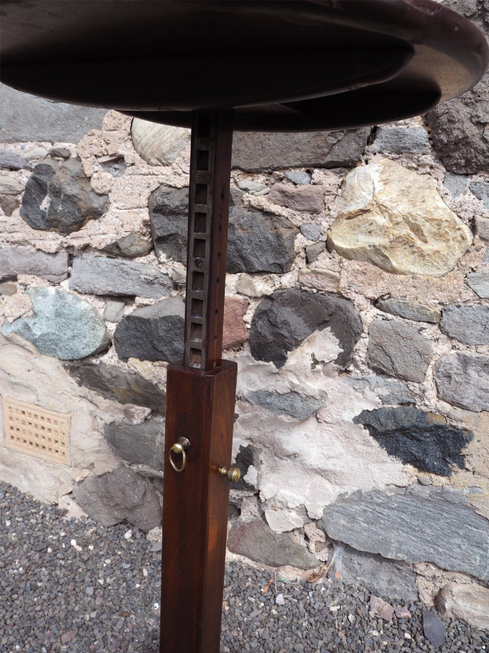 An early Georgian walnut candlestand featuring a circular dish-top surface set on a square adjustable pillar and a tripod base with cabriole legs. View VII