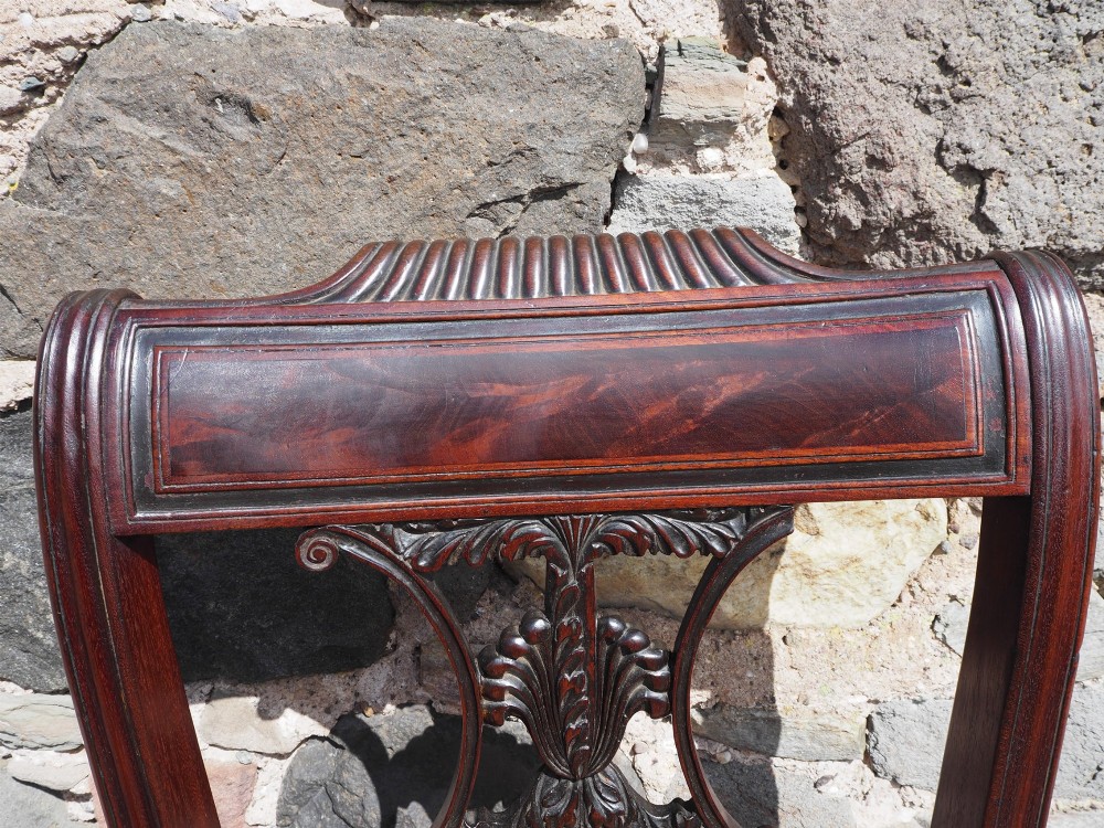 A Regency Cuban mahogany side chair featuring a carved crest rail, an anthemion splat, and a floral upholstered seat. View V