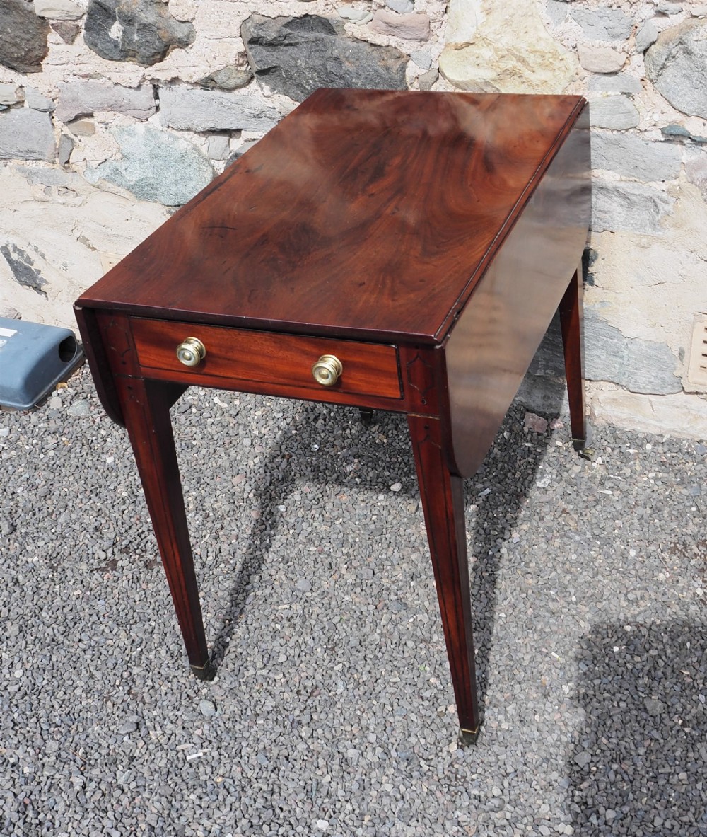 An 18th-century mahogany Pembroke table featuring two drop-leaf flaps, a single end drawer with brass knobs, and square tapered legs with subtle line inlay.