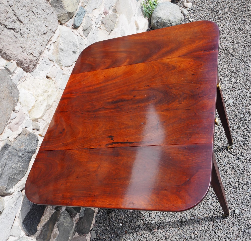 An 18th-century mahogany Pembroke table featuring two drop-leaf flaps, a single end drawer with brass knobs, and square tapered legs with subtle line inlay. View IV