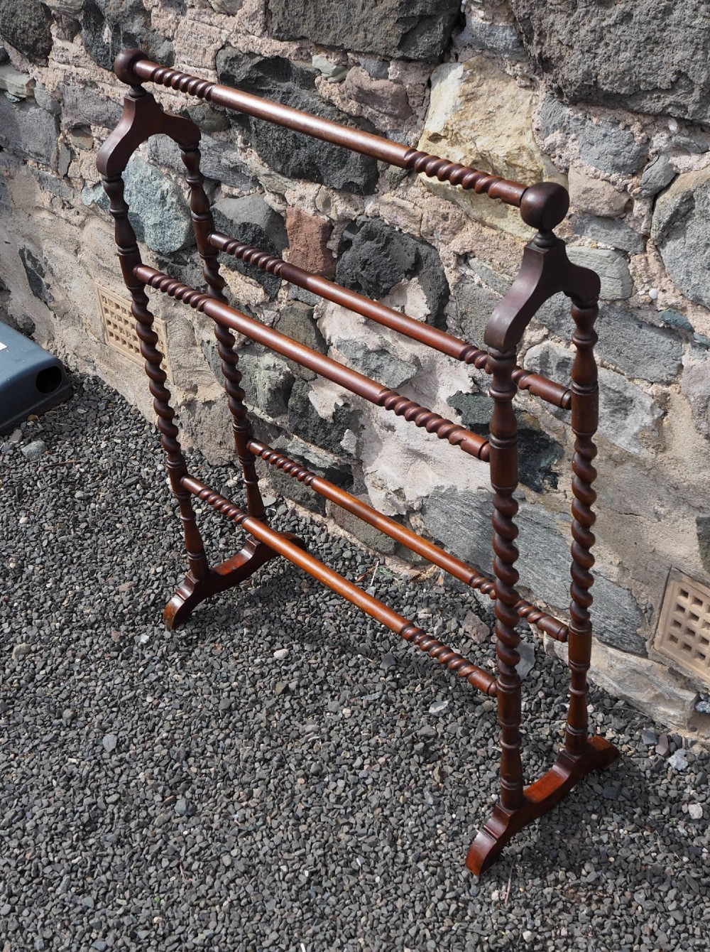 A freestanding Edwardian mahogany towel rail featuring barley twist turned uprights, horizontal crossbars, and curved trestle feet. View II
