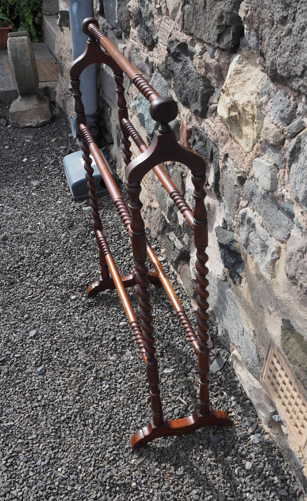 A freestanding Edwardian mahogany towel rail featuring barley twist turned uprights, horizontal crossbars, and curved trestle feet. View III
