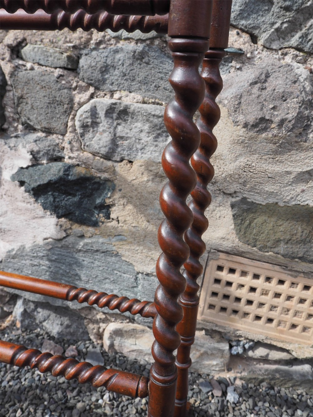 A freestanding Edwardian mahogany towel rail featuring barley twist turned uprights, horizontal crossbars, and curved trestle feet. View V