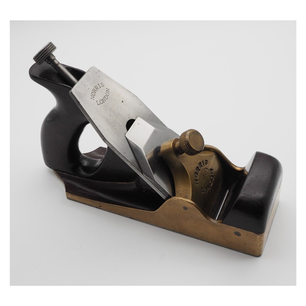 An antique Norris London 51G smoothing plane featuring a gunmetal frame, dark hardwood infill, and adjustable steel cutter. View III