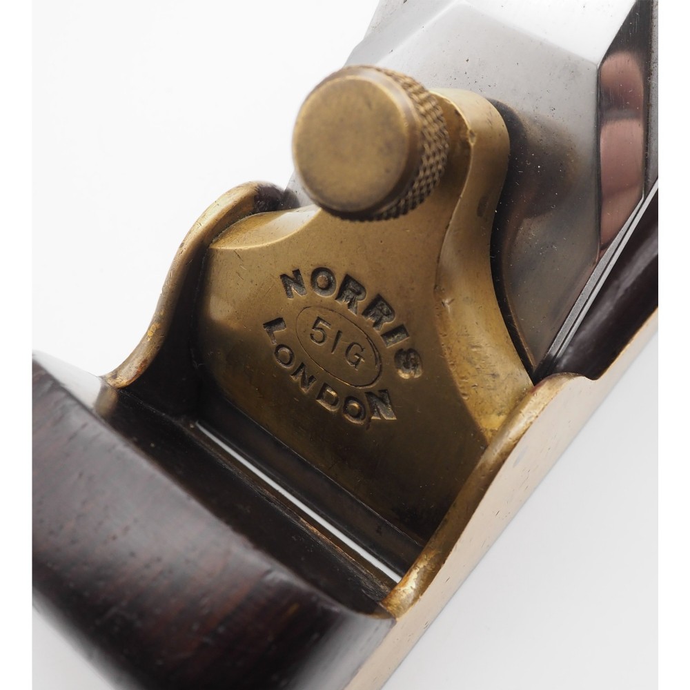 An antique Norris London 51G smoothing plane featuring a gunmetal frame, dark hardwood infill, and adjustable steel cutter. View VI