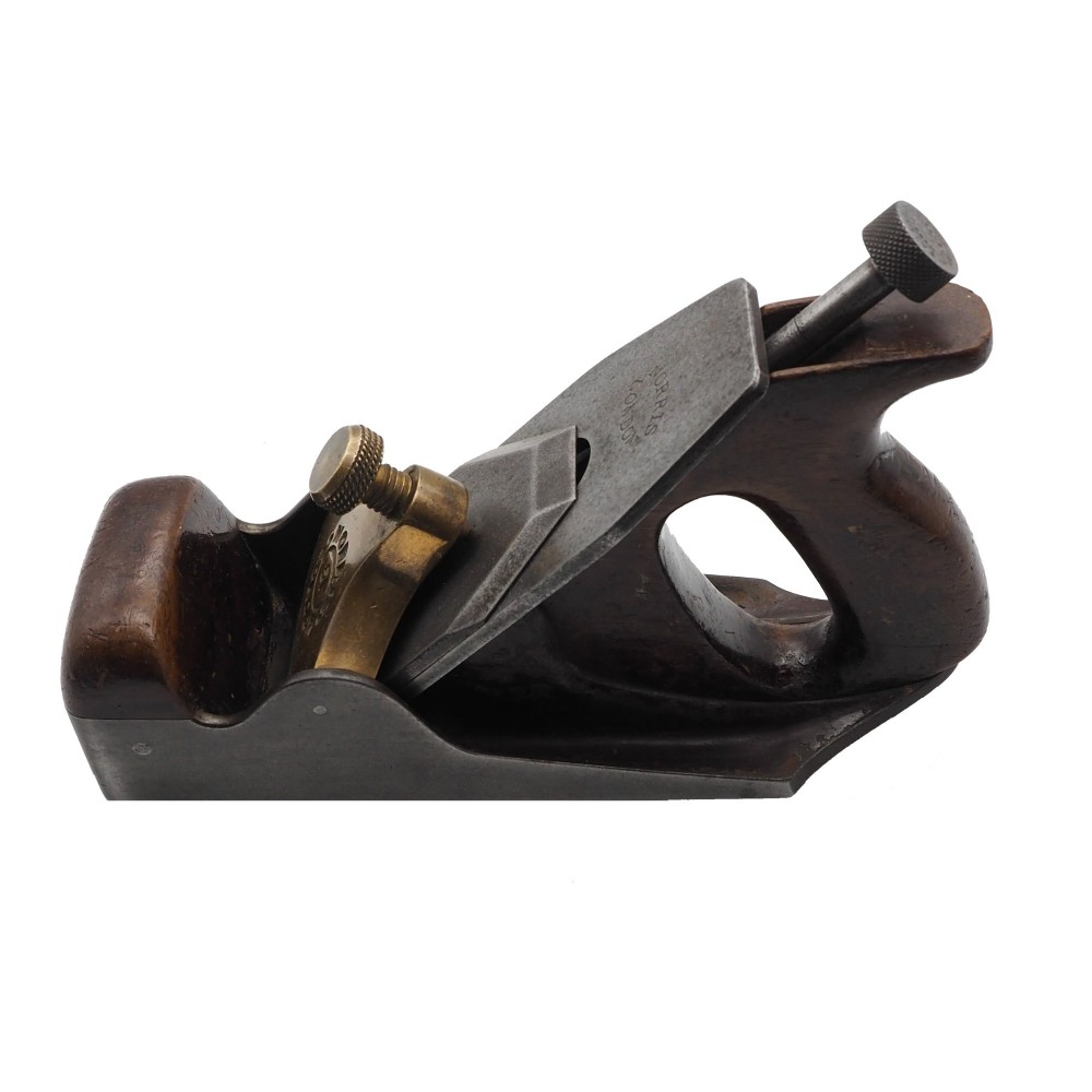 An antique Norris London A51 annealed iron smoothing plane featuring a dark hardwood infill, brass lever cap, and steel blade adjuster against a plain background. View III