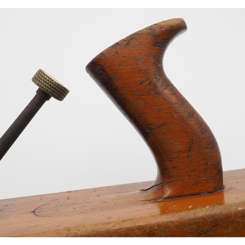 An antique wooden panel plane featuring a beech body, shaped rear handle, steel cutting iron, and brass adjustment mechanism. View IV