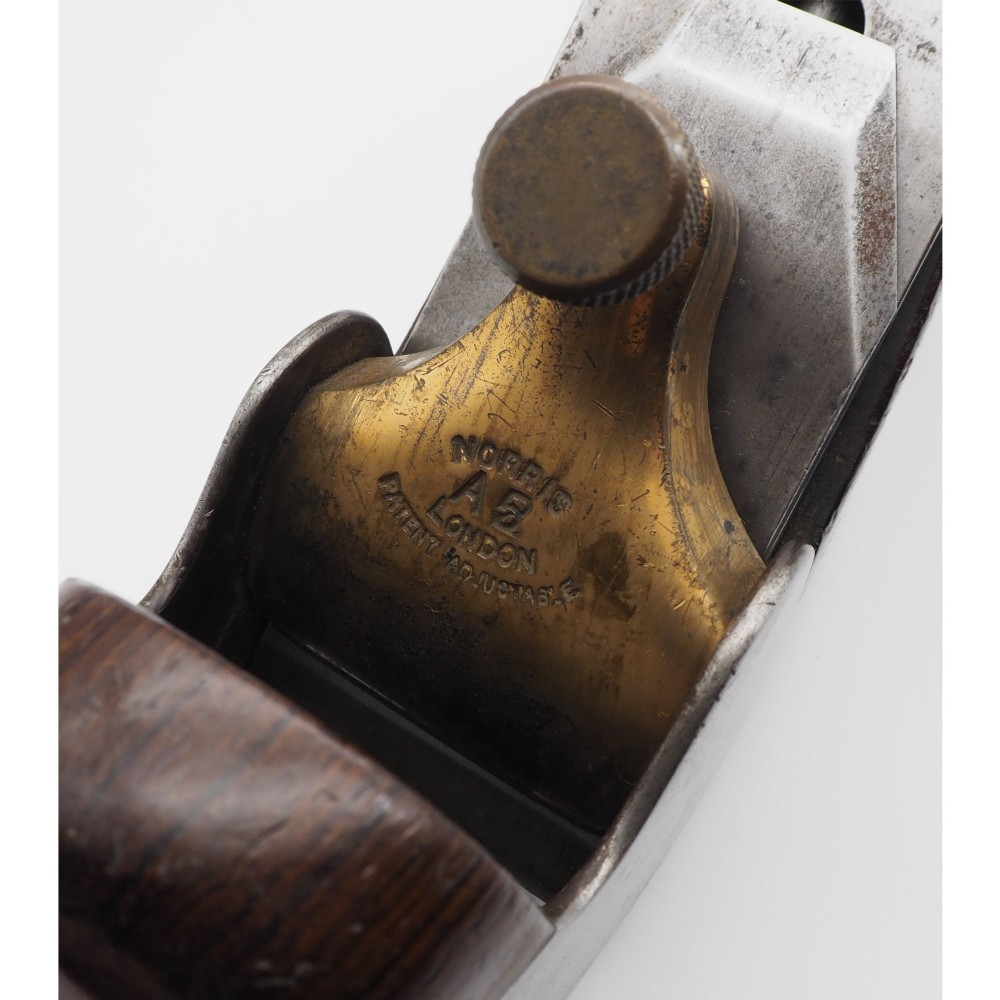 A Norris London A5 patent adjustable smoothing plane with a cast steel body, dark hardwood infill, and brass lever cap. View VI
