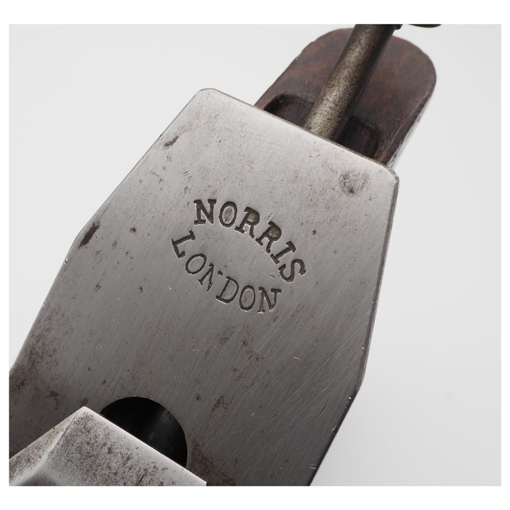 A Norris London A5 patent adjustable smoothing plane with a cast steel body, dark hardwood infill, and brass lever cap. View VII