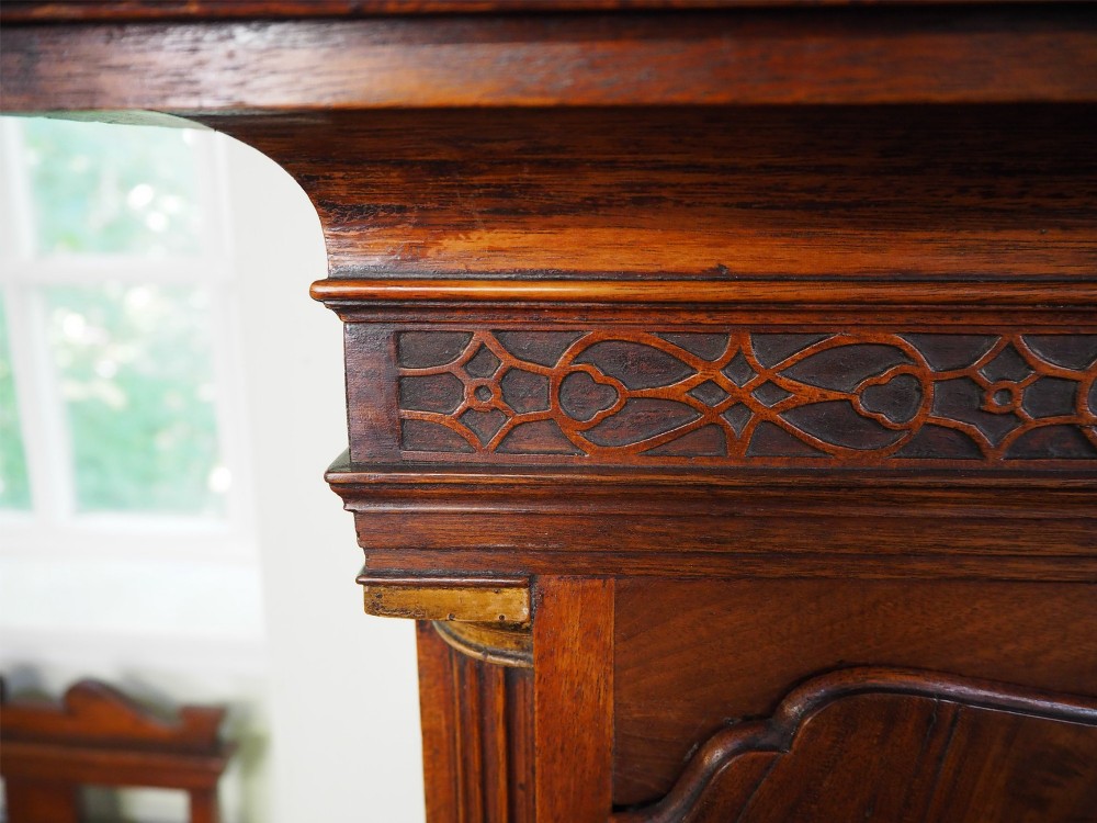 An eighteenth-century mahogany longcase clock featuring a swan-neck pediment with brass finials, an ornate brass dial with a moon phase arch, and a flame mahogany veneer trunk door. View VII