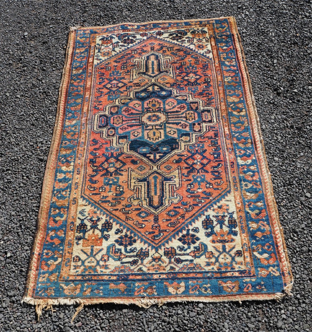 An antique Persian Hamadan hand-knotted wool rug featuring a central stepped medallion in blue, terracotta, and ivory tones with geometric borders. View II