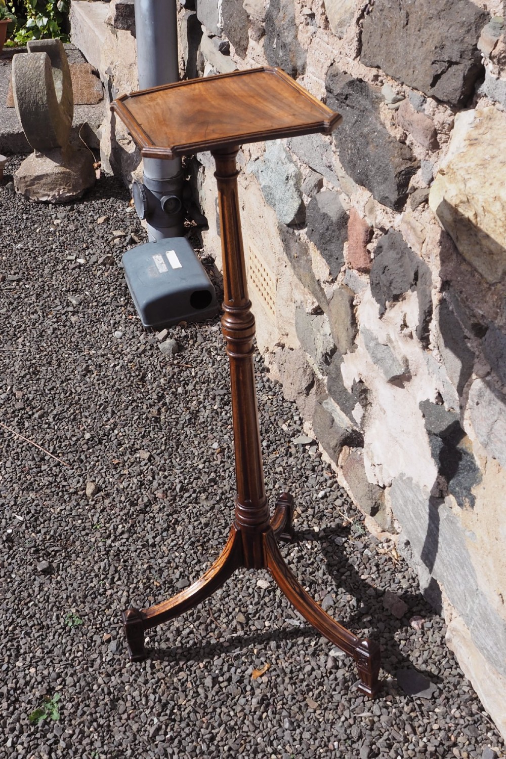 An 18th-century Dutch walnut torchere featuring a turned tapered column, shaped square tray top, and carved tripod legs. View II
