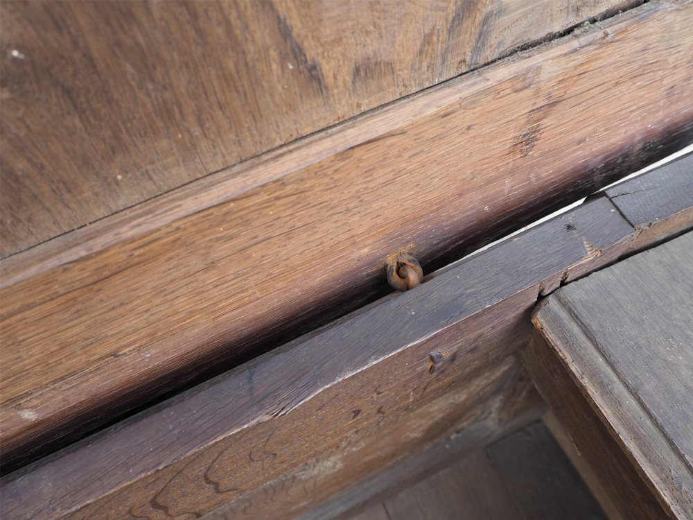 An early 18th-century oak coffer with a three-panel hinged top, carved rosette panels on the front, and a brass keyhole escutcheon. View VIII