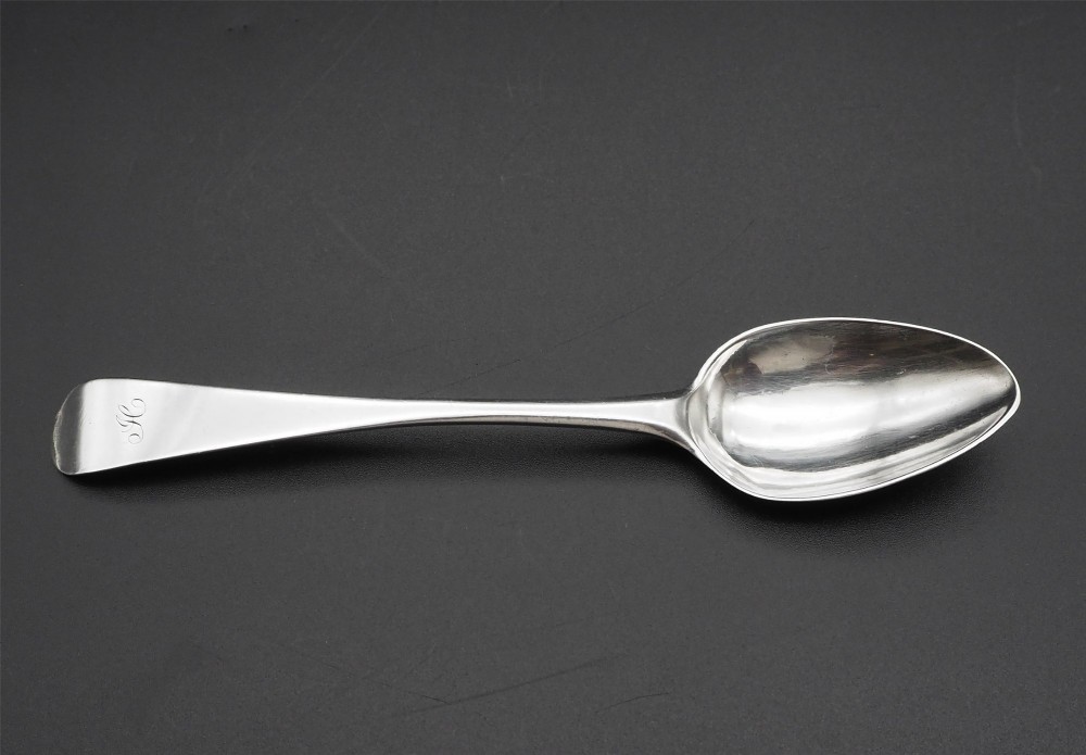 A set of four antique Scottish silver teaspoons with engraved terminal monograms displayed against a dark background. View III