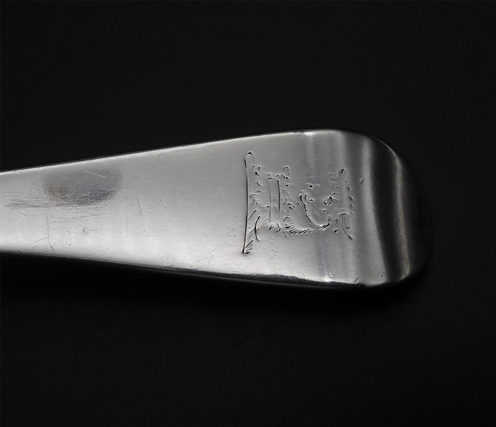 A Georgian sterling silver basting spoon featuring an elongated stem and deep oval bowl on a dark surface. View IV