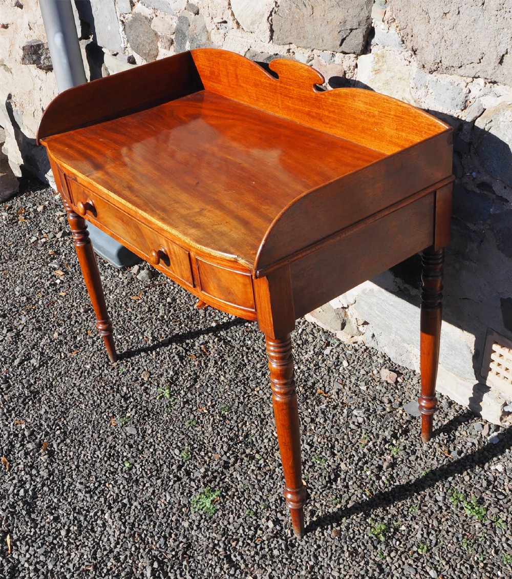 A Georgian mahogany dressing table featuring a raised gallery back, a single drawer with turned wooden knobs, and slender turned legs. View II